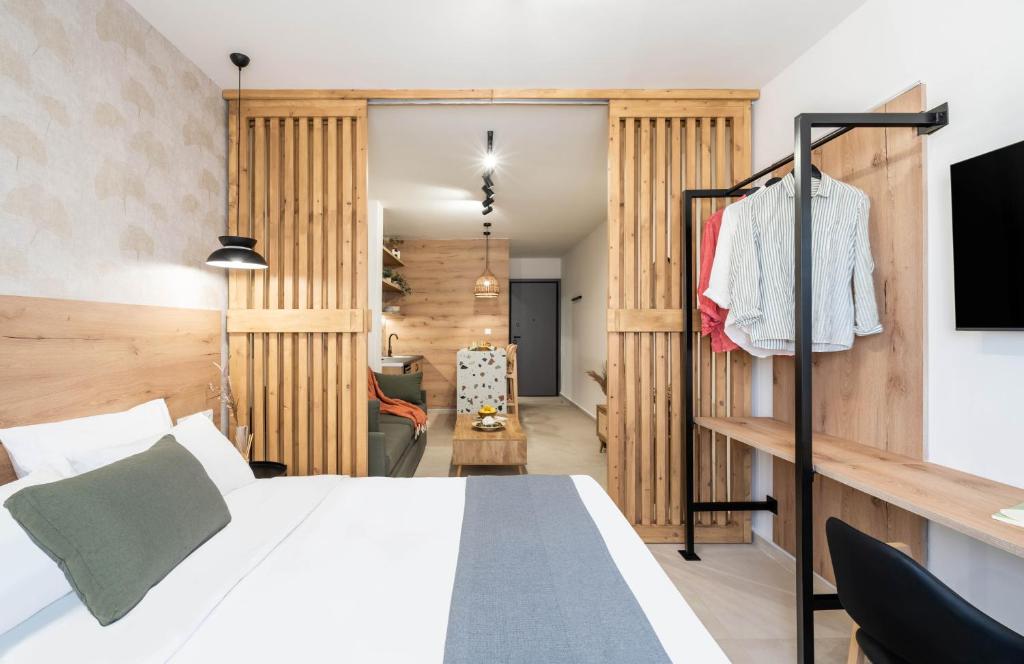 a bedroom with a white bed and a tv at KOYO Athens in Athens
