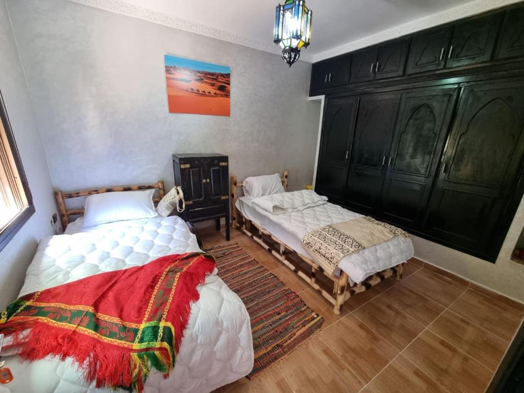 1 Schlafzimmer mit 2 Betten und einem Kronleuchter in der Unterkunft auberge gite de jeunesse les Cascades in Setti Fatma