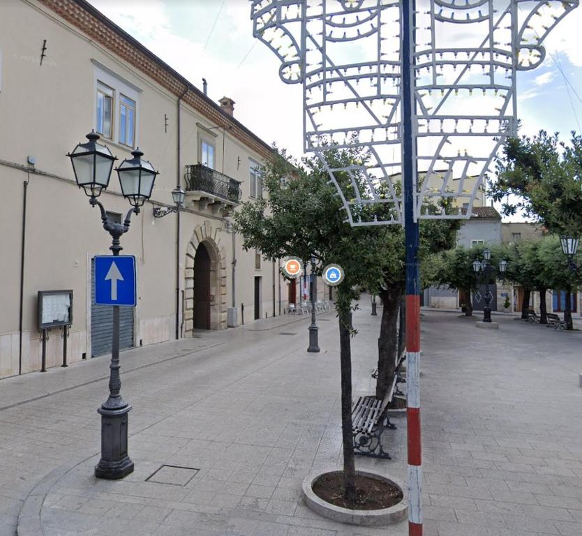 eine Straße mit Straßenbeleuchtung und einem Baum auf einer Straße in der Unterkunft Palazzo dei Baroni in San Bartolomeo in Galdo