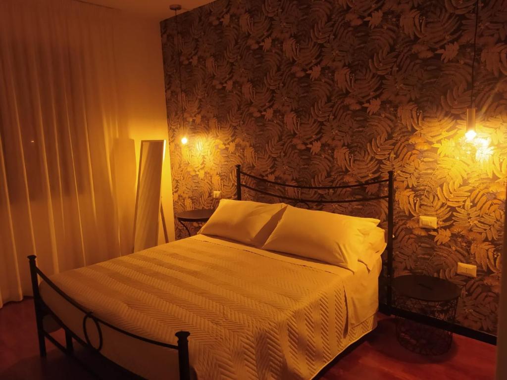 una camera da letto con un letto con lenzuola bianche e un muro di Anema Home a Serino