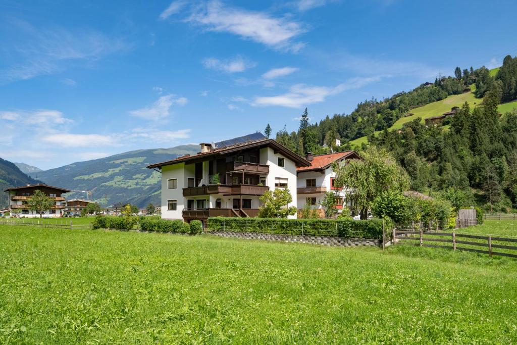 a house in the middle of a green field at Ferienwohnung Wallner in Zell am Ziller