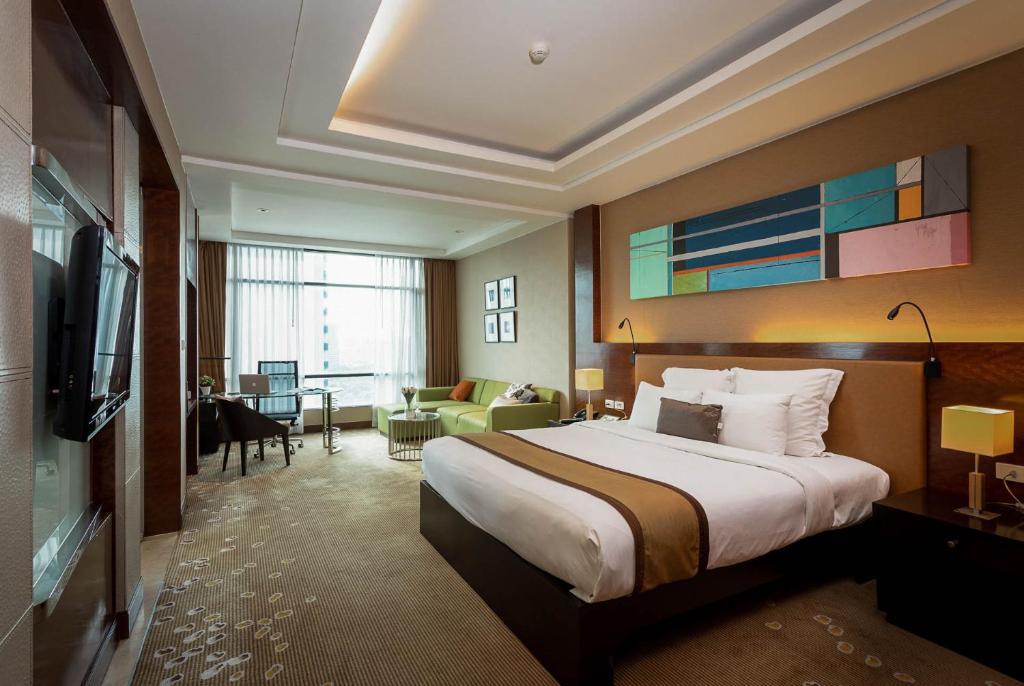 Habitación de hotel con cama y sala de estar. en AETAS lumpini, en Bangkok