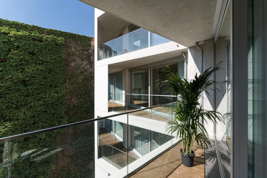 a house with glass walls and a plant on the balcony at Carlotta Apartments in Berlin