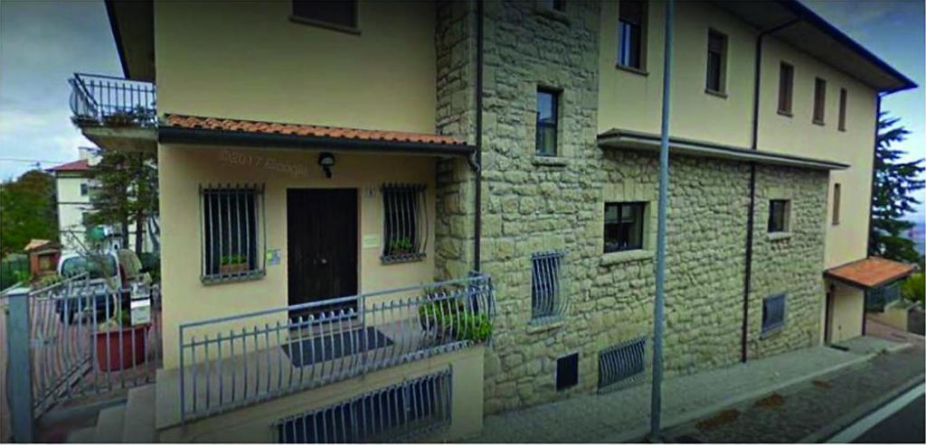 un edificio in mattoni con balcone sul lato di Stabat Mater Casa di Preghiera a Valdragone