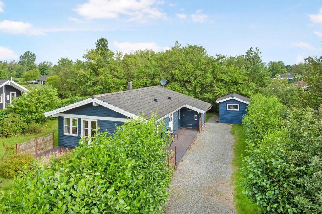 ein blaues Haus mitten im Garten in der Unterkunft Cozy Cottage In A Quiet Area Close To The Beach in Dannemare