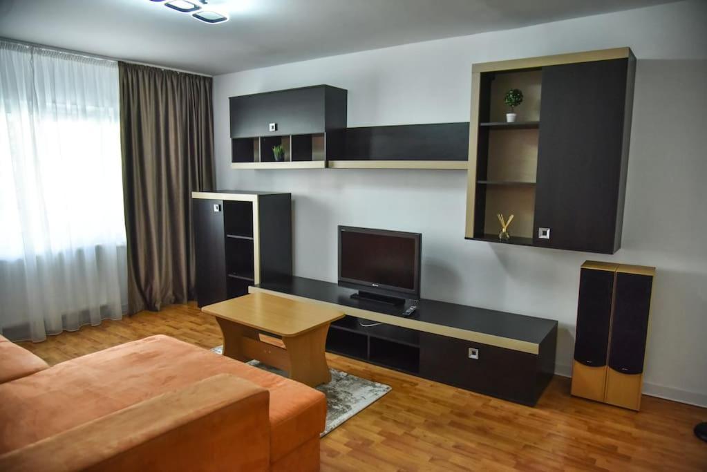 een woonkamer met een bank en een bureau bij Apartament 3 camere In centru in Râmnicu Vâlcea