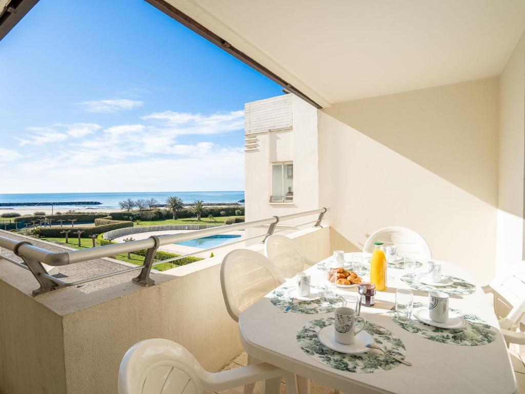 un balcon avec une table et des chaises et une vue sur l'océan dans l'établissement Apartment Les Rivages de Rochelongue-2 by Interhome, au Cap d'Agde