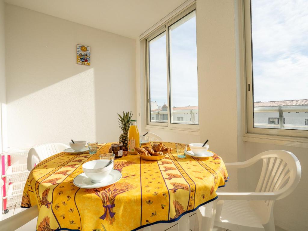 阿格德角的住宿－勒卡普達格德拉帕姆公寓，用餐室配有带黄桌布的桌子