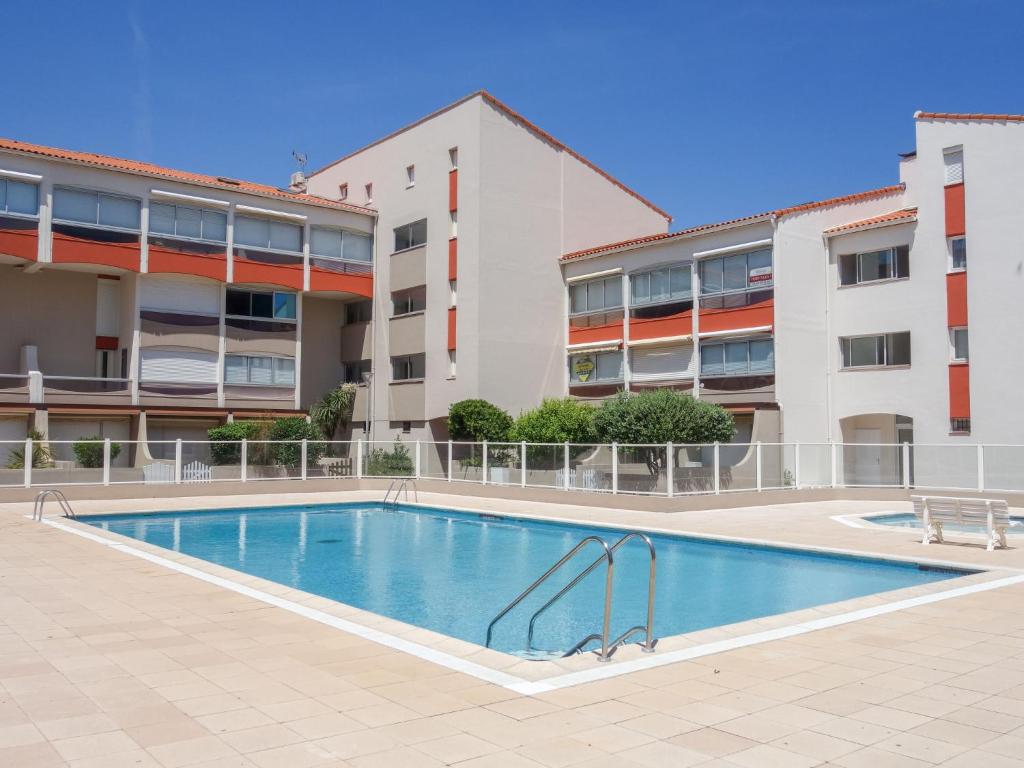 a swimming pool in front of a building at Apartment Les Golfes Clairs by Interhome in Plage dʼArgelès