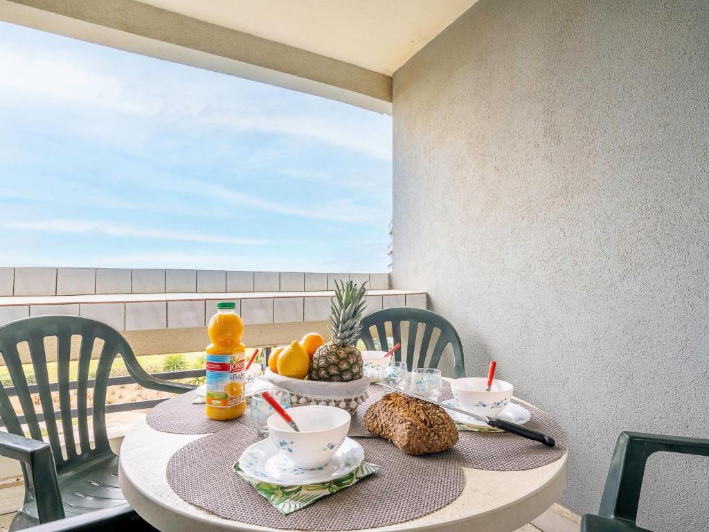- une table avec de la nourriture et des fruits sur un balcon dans l'établissement Apartment Le Beaupré-2 by Interhome, à Canet