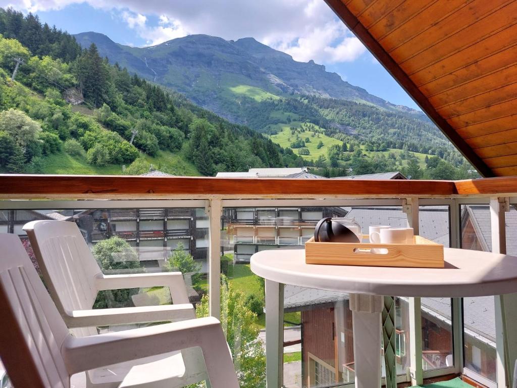 une table et des chaises sur un balcon avec vue sur une montagne dans l'établissement Apartment Les Combettes D et E by Interhome, aux Contamines-Montjoie
