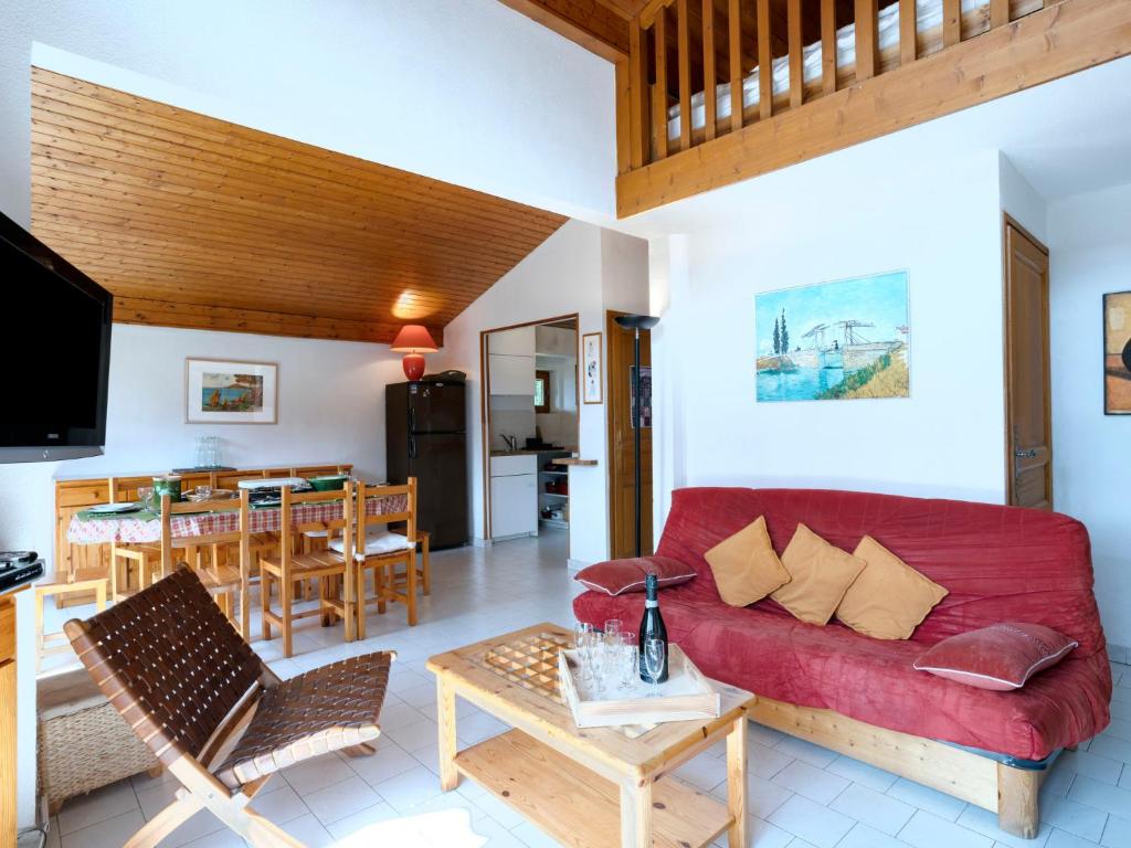 sala de estar con sofá rojo y mesa en Apartment le Martagon-1 by Interhome, en Saint-Gervais-les-Bains