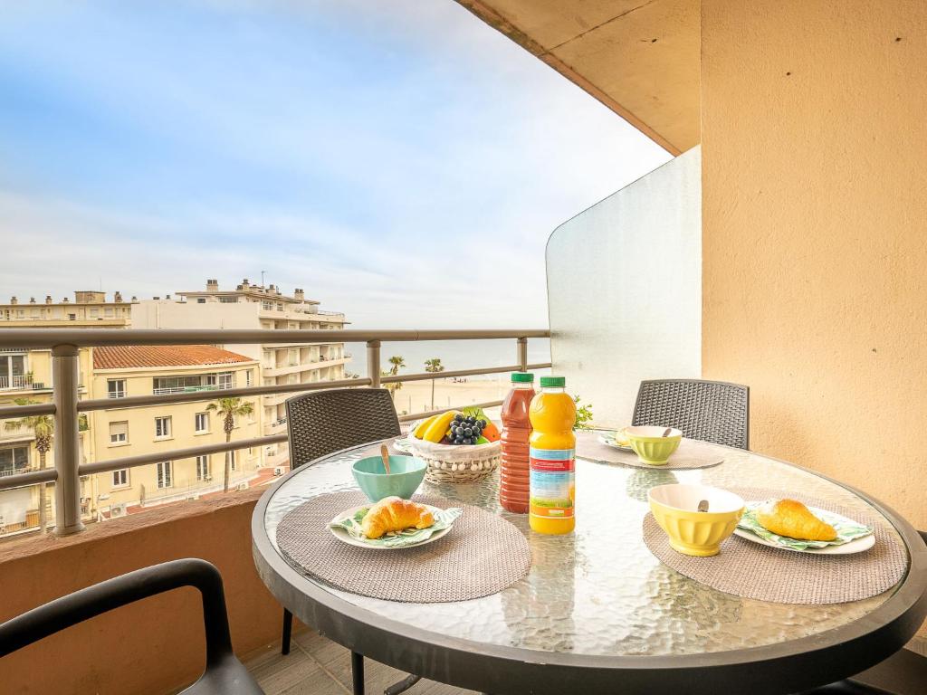 une table avec des assiettes de nourriture sur un balcon dans l'établissement Apartment Le régent-1 by Interhome, à Canet