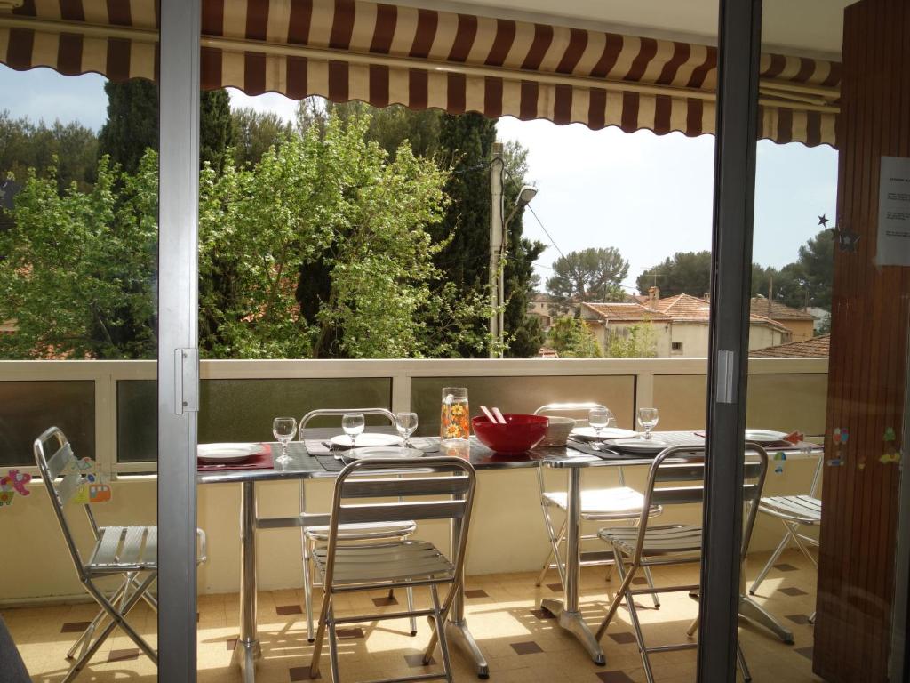 patio ze stołem i krzesłami na balkonie w obiekcie Apartment Le Paradou by Interhome w mieście Virebelle