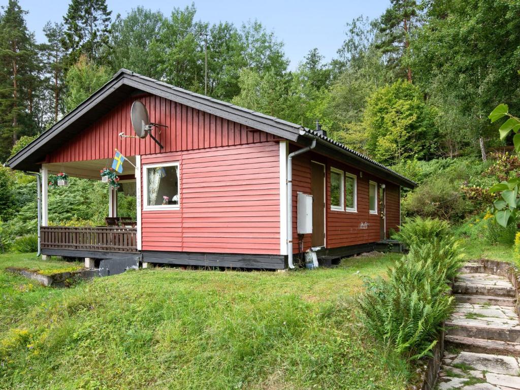 una cabina roja en medio de un campo en Chalet Västanvik Snickarhagen - OST047 by Interhome, en Motala