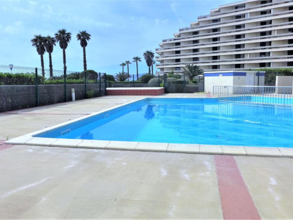 una gran piscina con un gran edificio en el fondo en Apartment Grand Sud-4 by Interhome, en Canet-en-Roussillon