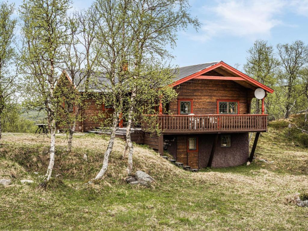 a log cabin with a deck in the woods at Chalet Fjällnäs - HJD025 by Interhome in Tänndalen