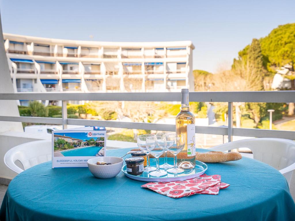 - une table bleue avec une bouteille de vin et des verres dans l'établissement Apartment Tahiti-2 by Interhome, à La Grande Motte
