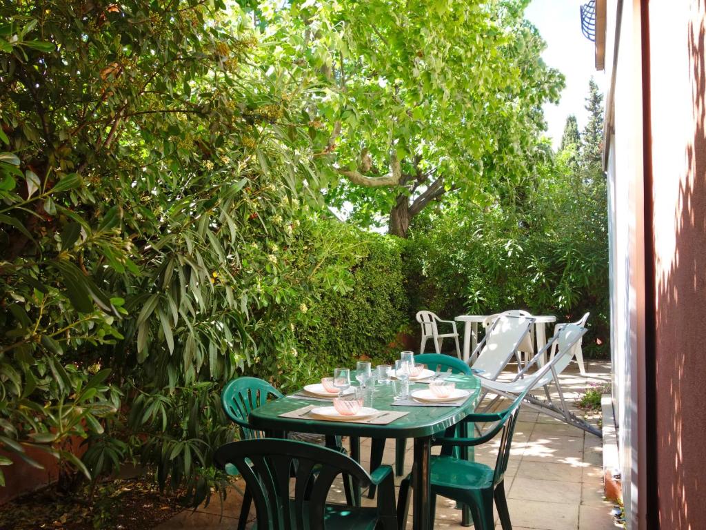 a green table and chairs on a patio at Apartment Les Jardins de Neptune by Interhome in Virebelle