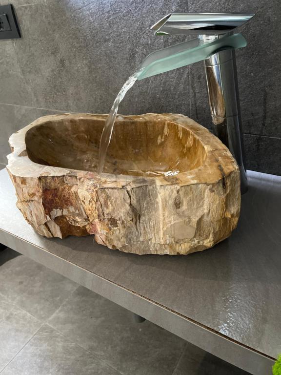 ein Steinwaschbecken mit einem Wasserhahn auf der Theke in der Unterkunft Cinecittà Luxury GUEST HOUSE in Rom
