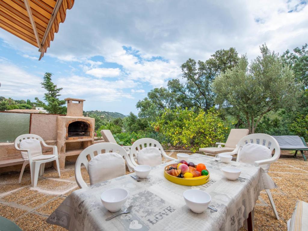 - une table et des chaises avec un bol de fruits sur la terrasse dans l'établissement Apartment Valao Verde by Interhome, à Cavalaire-sur-Mer