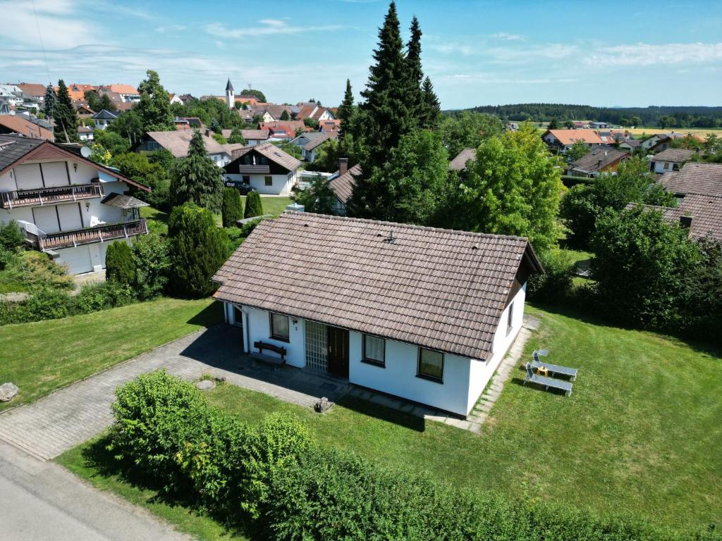 ein kleines weißes Haus mit einem Dach auf einem grünen Feld in der Unterkunft Holiday Home Vergissmeinnicht by Interhome in Dittishausen