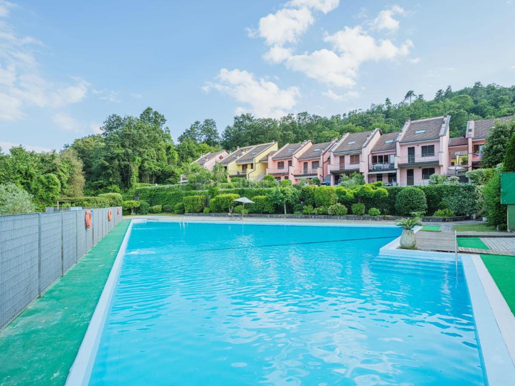 a swimming pool with blue water in front of houses at Apartment Villaggio 5 Terre-4 by Interhome in Soviore