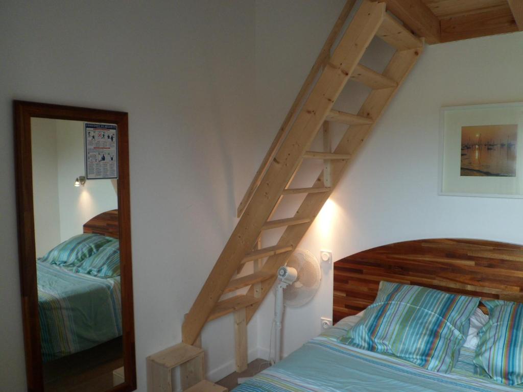 a bedroom with a wooden staircase next to a bed at Hotel du Cap in Cap-Ferret