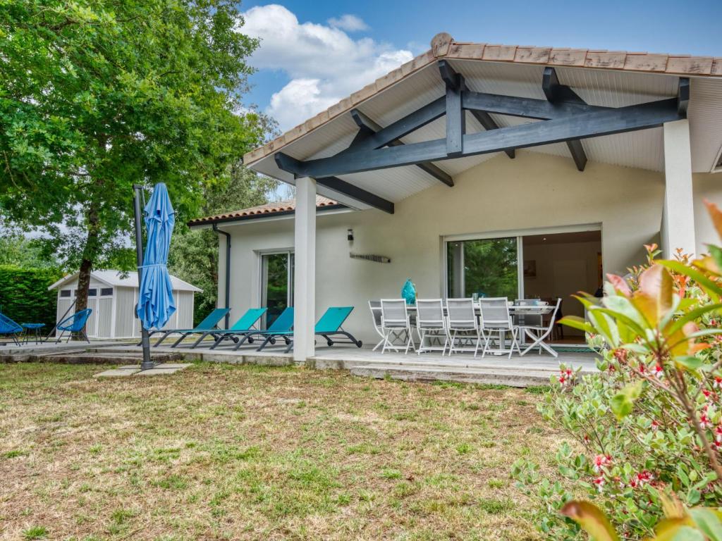 un patio con sillas y sombrillas frente a una casa en Villa Petite Dépée by Interhome, en Grayan-et-lʼHôpital