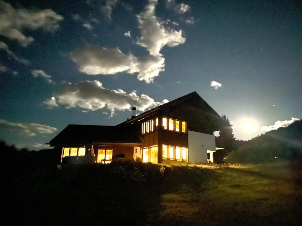 a house with the sun setting behind it at Chalet Familial Capricorne in Vercorin