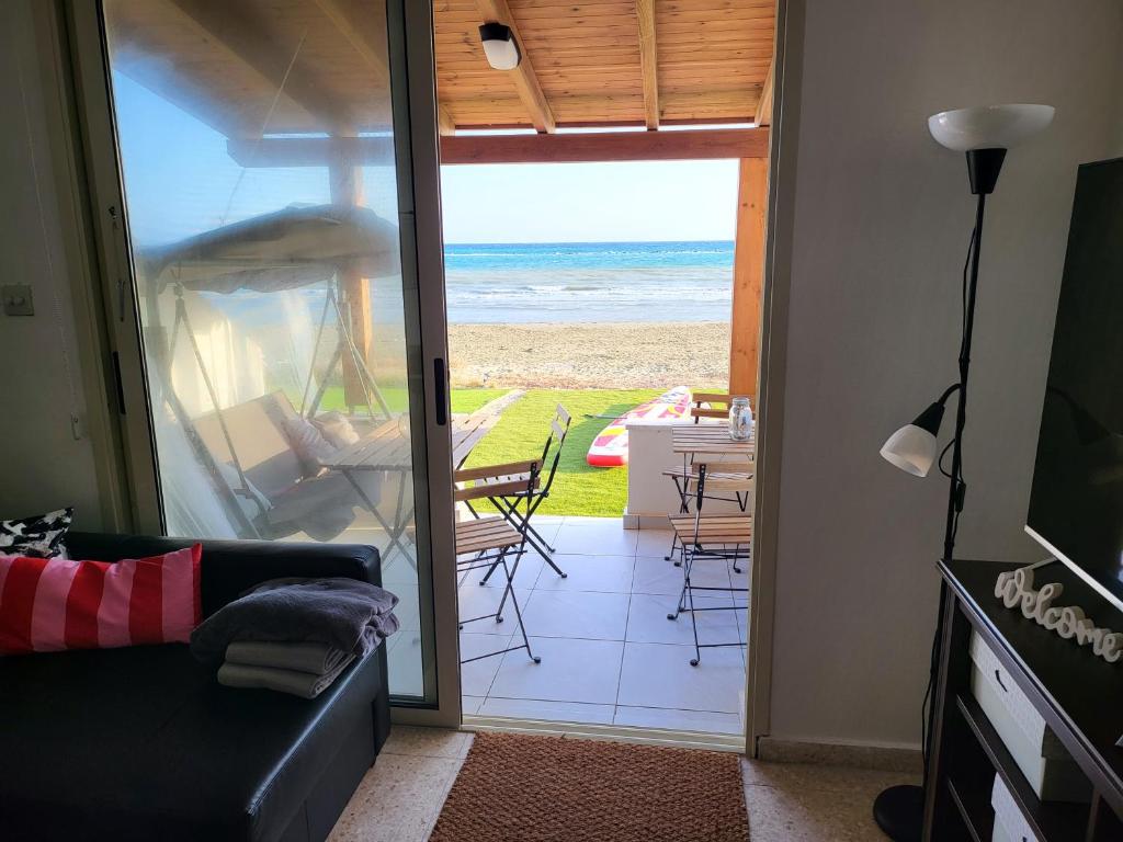 een woonkamer met een bank en uitzicht op de oceaan bij Mattis Seafront Beachhouse in Perivolia