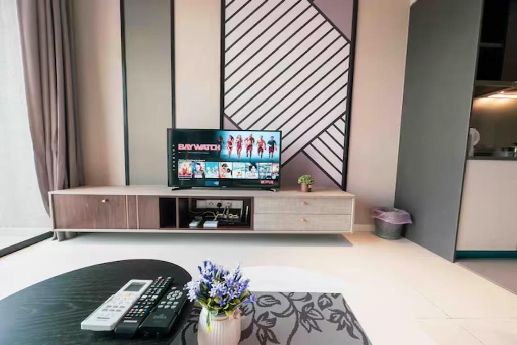 a living room with a tv and a table at Millerz Cozy Home by GUESTONIC in Kuala Lumpur