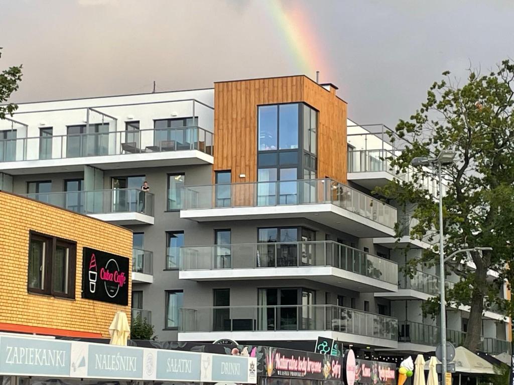 um arco-íris no céu acima de um edifício em Portowy Boulevard em Mrzeżyno