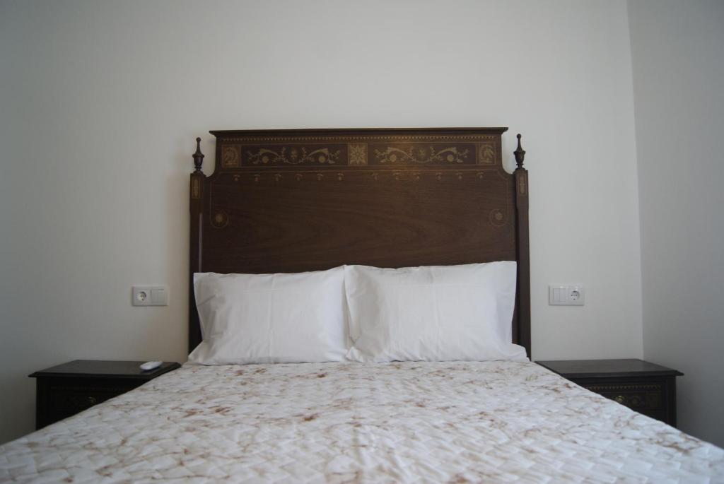 um quarto com uma cama grande e almofadas brancas em 3 L's STAY em Castro Daire