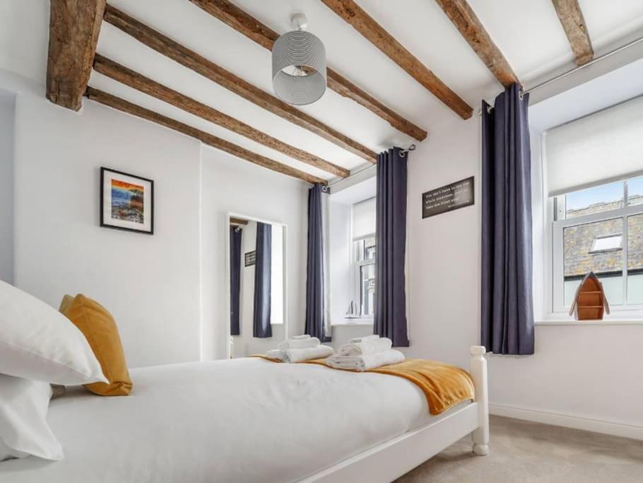 - une chambre avec un grand lit blanc et des rideaux bleus dans l'établissement Characterful 3 Bedroom Cottage, à Aberystwyth