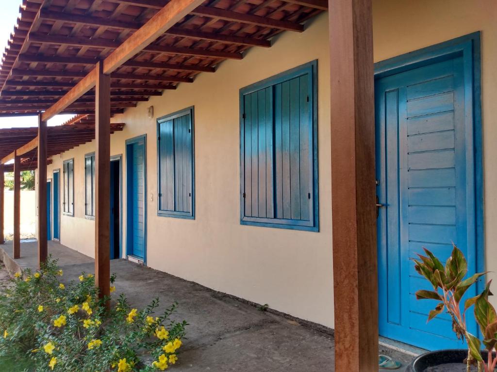 una fila de puertas azules en una casa en Pousada Pérola do Rio en Barreirinhas