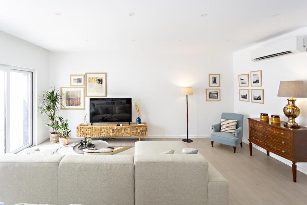 a living room with a couch and a tv at Special Cabanas in Tavira