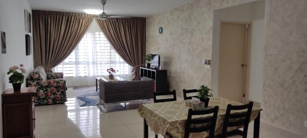 a living room with a table and chairs and a living room at Al Fateh Homestay Apartment in Putrajaya in Putrajaya