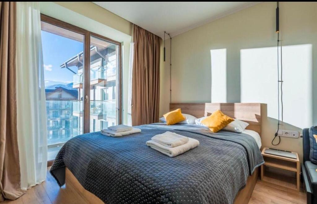 a bedroom with a bed with a large window at New Gudauri Redco Premium Apartments in Gudauri