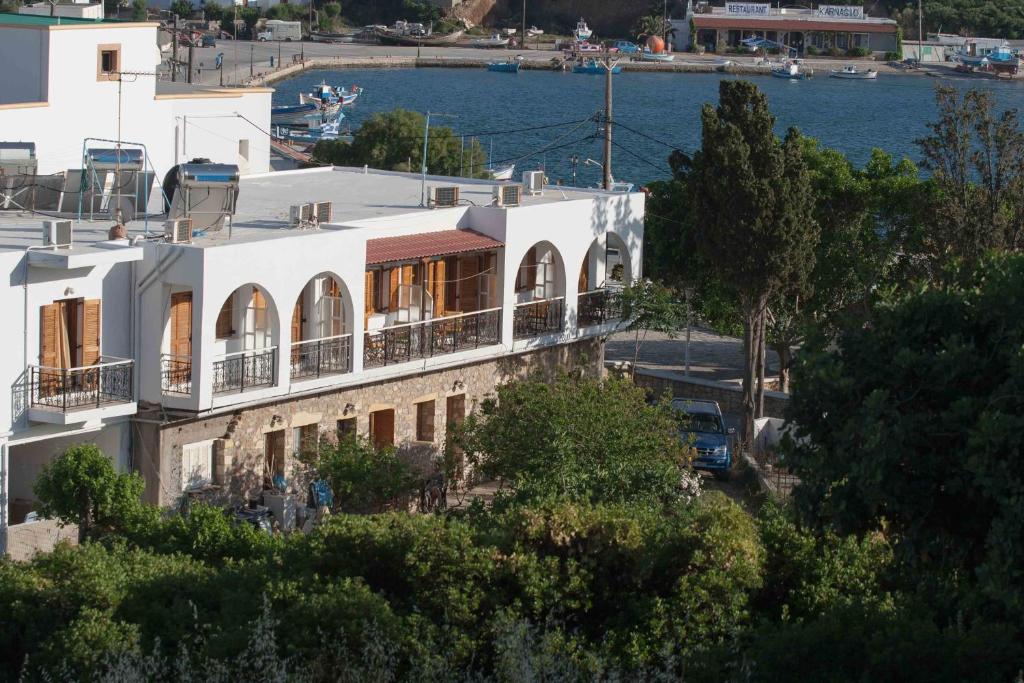 a white building with a balcony and the water at Michalis Studios in Lipsoi