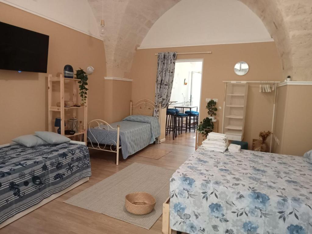 Sala de estar con 2 camas y mesa en Casina Al Maestrale en San Pancrazio Salentino