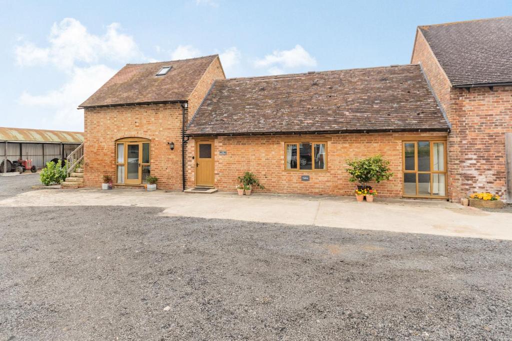 a brick house with a driveway in front of it at The Granary at Lane End Farm in Evesham