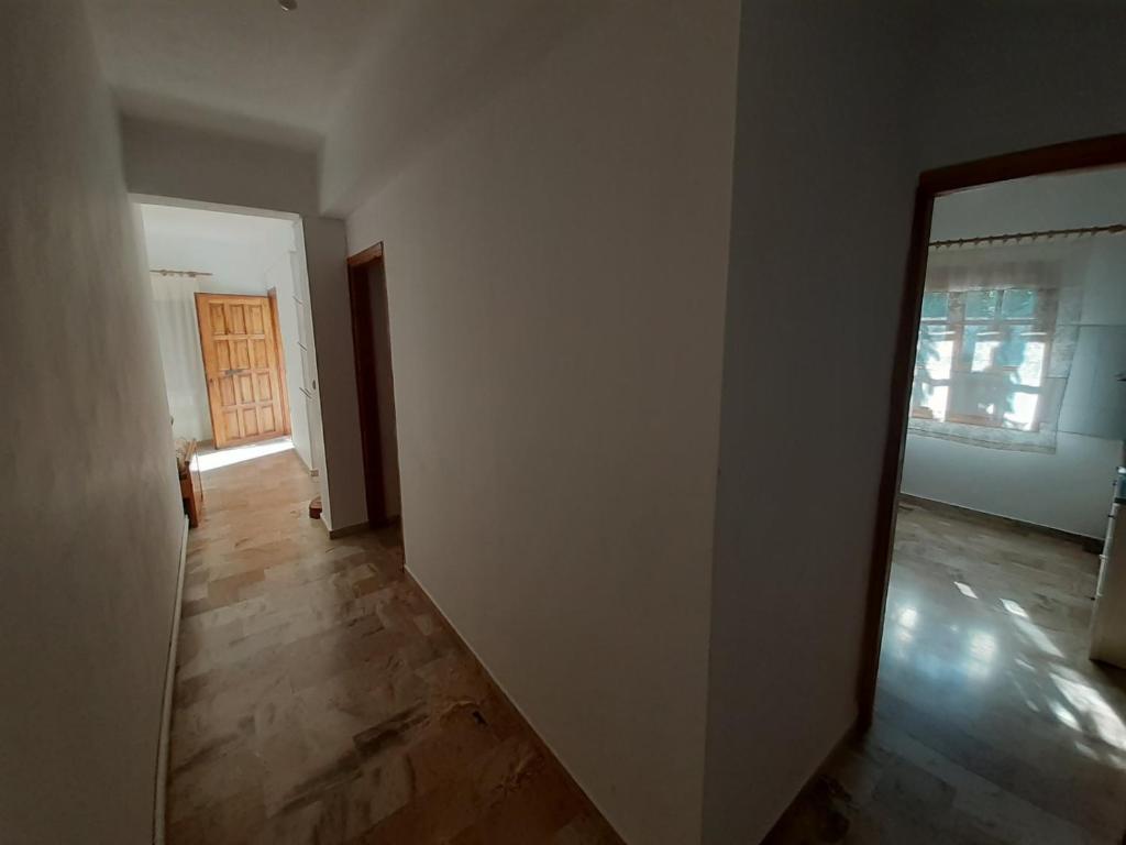 ein leeres Zimmer mit einer Tür und einem Holzboden in der Unterkunft Glyfada's Family Apartment in Glyfada Fokidas