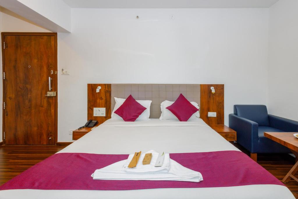 a hotel room with a bed with two towels on it at J Hotel and Banquets in Mumbai
