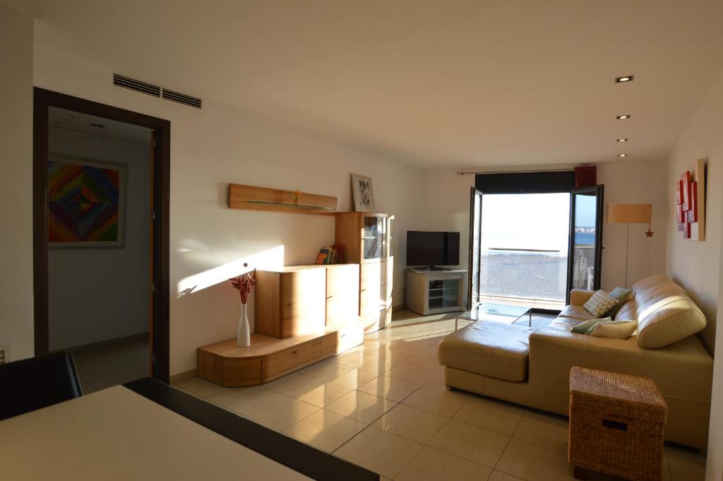 ein Wohnzimmer mit einem Sofa und einem Tisch in der Unterkunft Apartamento delante del mar in Can Pastilla