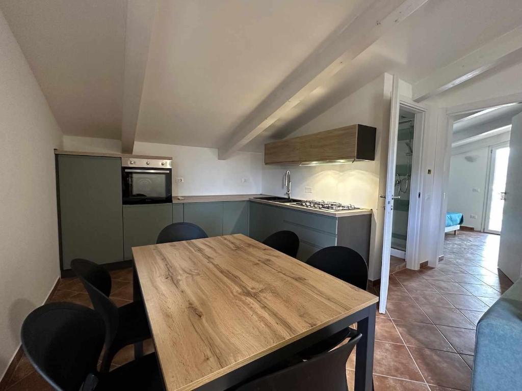 eine Küche und ein Esszimmer mit einem Holztisch und Stühlen in der Unterkunft Appartamento Santa Lucia E in Policastro Bussentino