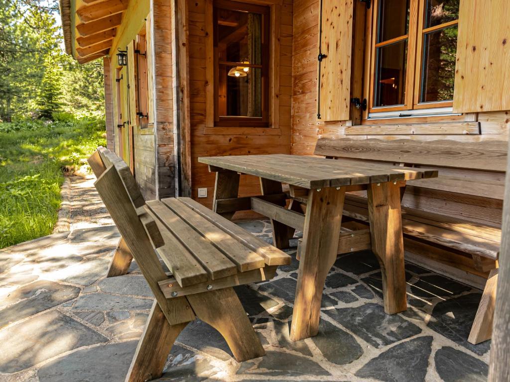 a wooden picnic table and a bench outside of a cabin at Alpin-Hütten auf der Turracherhöhe Haus Murmeltier by S4Y in Turracher Hohe
