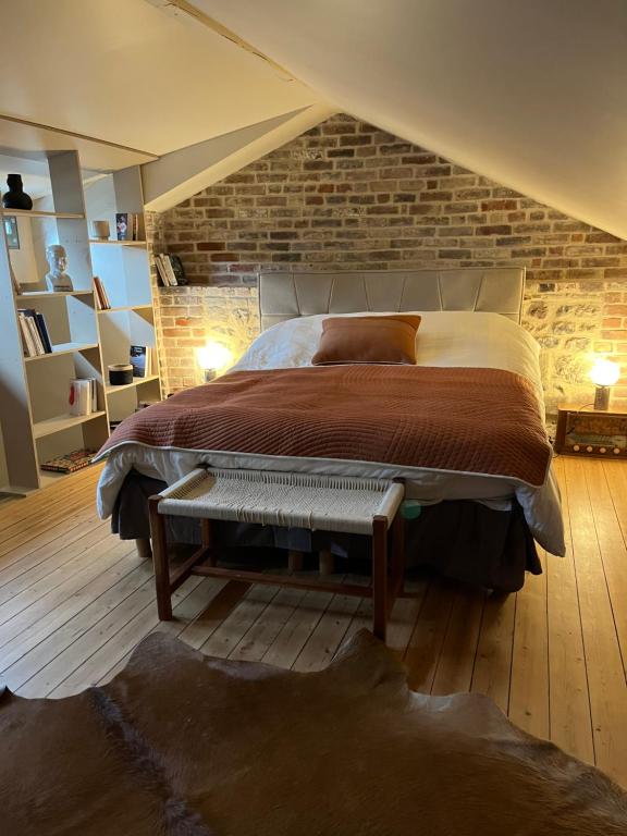 een slaapkamer met een groot bed en een bakstenen muur bij Le GYPSY - CHARME & EMPLACEMENT PARFAIT in Honfleur