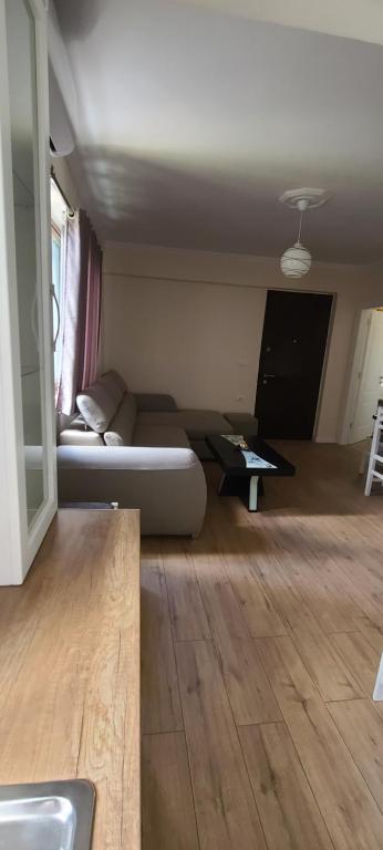 ein Wohnzimmer mit einem Sofa und einem Tisch in der Unterkunft Brand New Apartment Gjirokaster in Gjirokastër