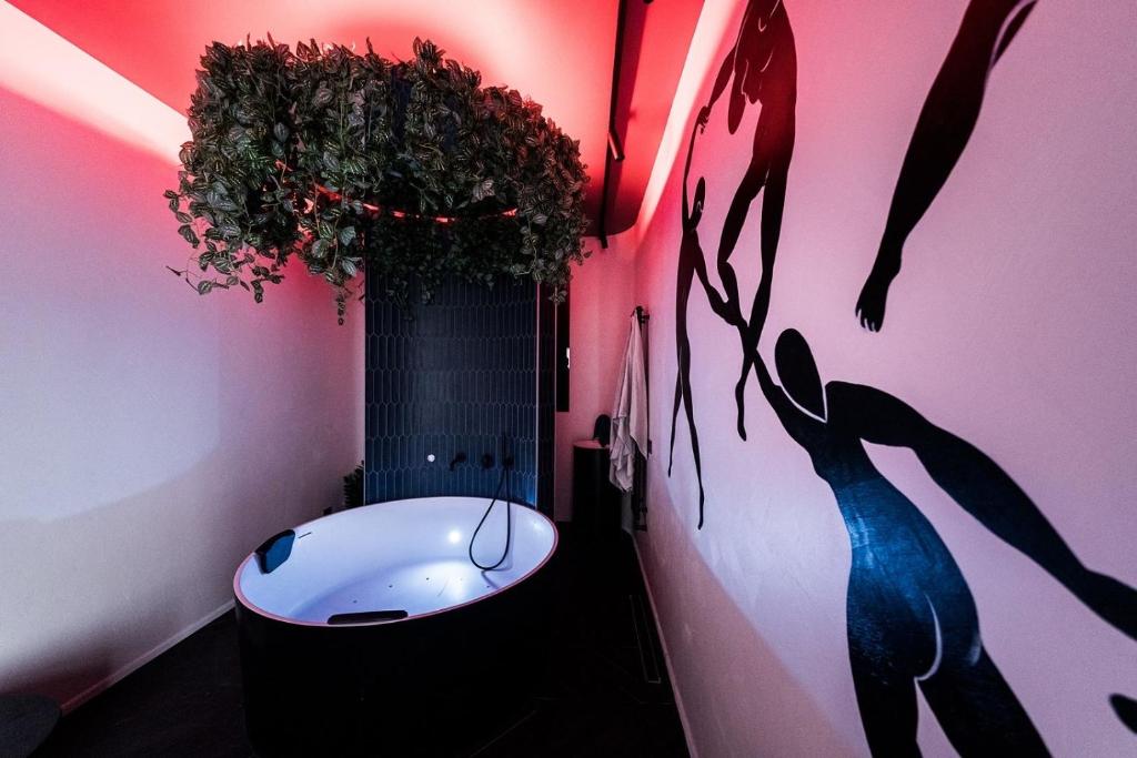 ein Badezimmer mit einer weißen Badewanne und einer rosa Wand in der Unterkunft Butas su Jacuzzi Kauno miesto centre in Kaunas